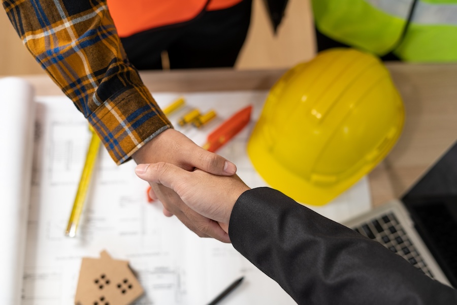 agent shakes hands with construction team leader