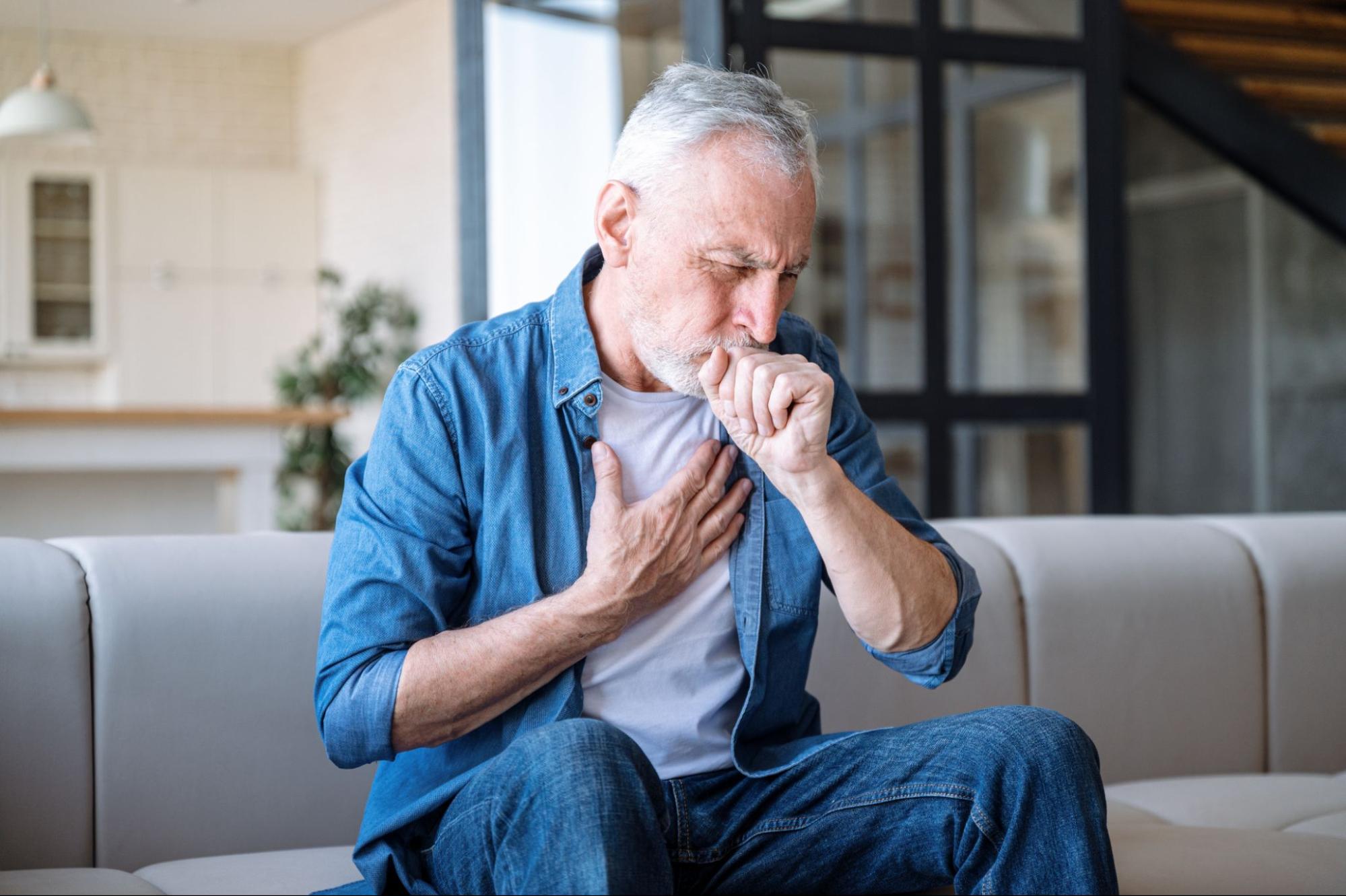 man coughing holding chest